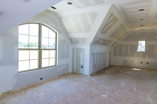 Int&eacute;rieur d'une maison en construction avec plafond partiellement install&eacute;