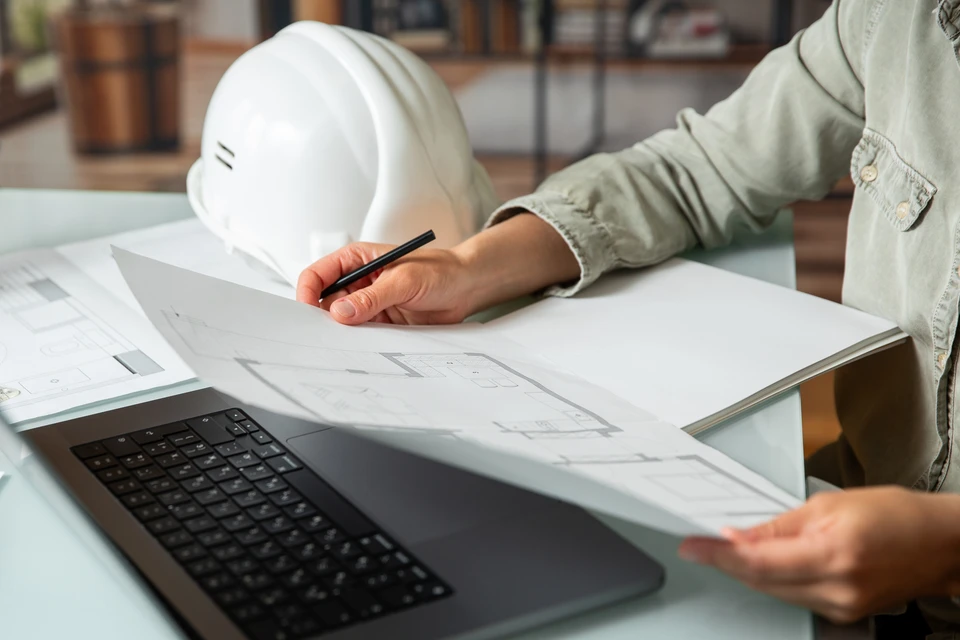Espace de travail intérieur avec outils de construction et planification disposés sur surface en bois naturel