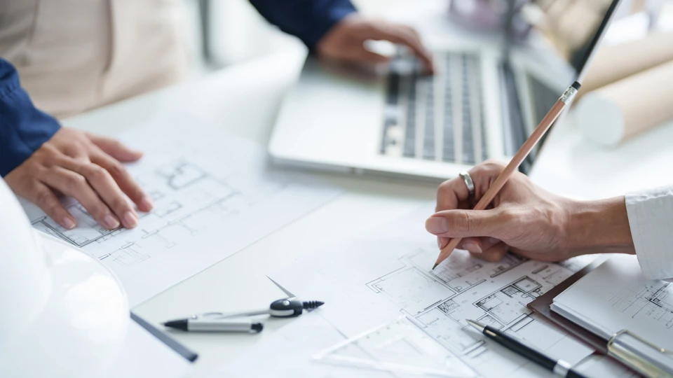 Homme en polo orange installant un parquet flottant dans une pi&egrave;ce r&eacute;sidentielle